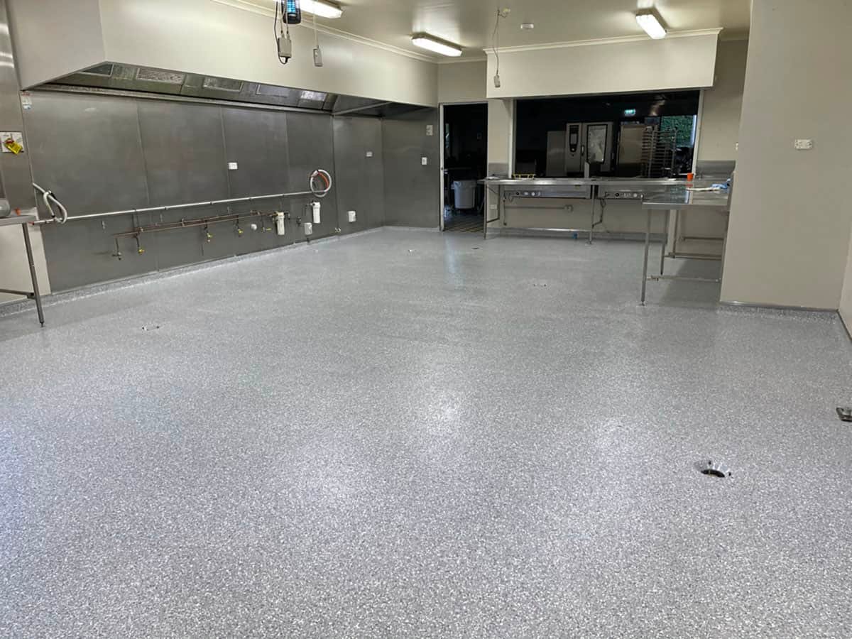 Commercial kitchen epoxy flooring system with a seamless gray flake finish