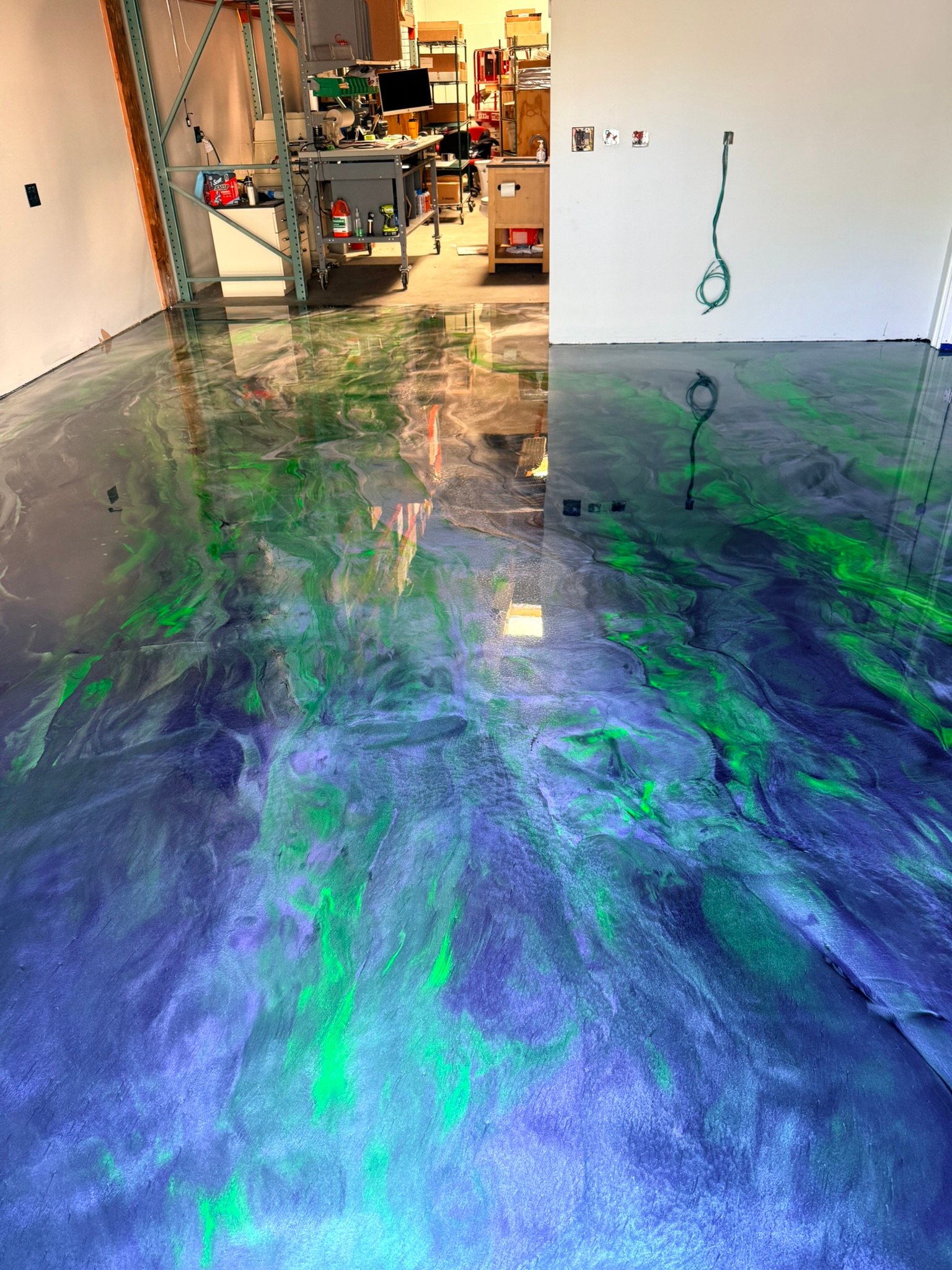 Custom green blue and gray metallic epoxy floor for a commercial workspace